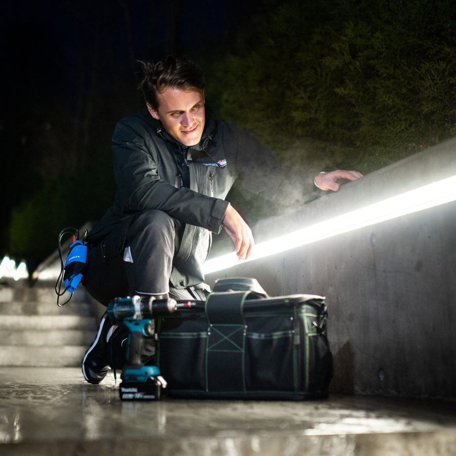 Elektriker monterer LED-lys som utebelysning på kvelden